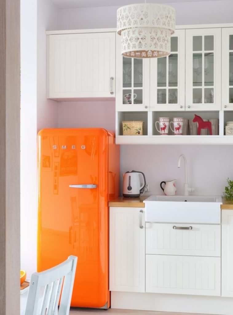Оранжевый холодильник в кухне с белой мебелью