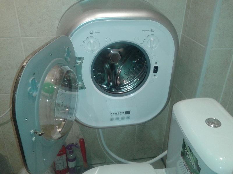 Компактная стиральная машинка на стене в ванной комнате
