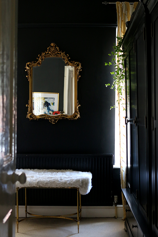 black bedroom with gold ornate mirror and black wardrobes - see more on www.swoonworthy.co.uk