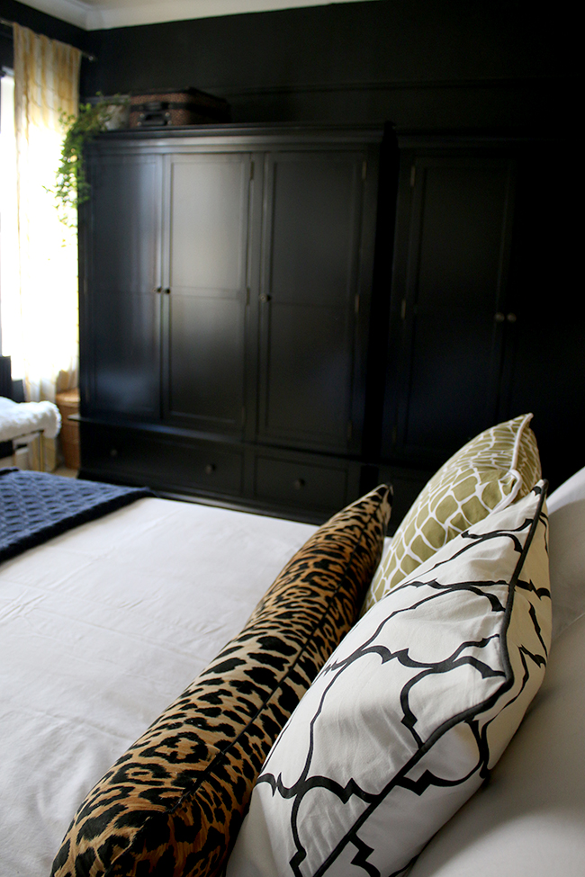 black wardrobes in black bedroom with colourful accents - see more on www.swoonworthy.co.uk